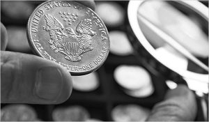 A coin grader checking a One Dollar US silver coin
